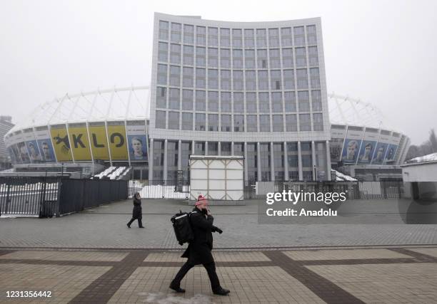 Man wearing a face mask walks next to the Olimpic Stadium on a street during the coronavirus COVID-19 pandemic in Kiev, Ukraine, on February 24,...