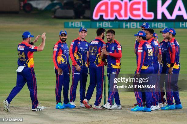 Karachi Kings' Mohammad Amir celebrates with teammates after taking the wicket of Islamabad United's captain Shadab Khan during the Pakistan Super...