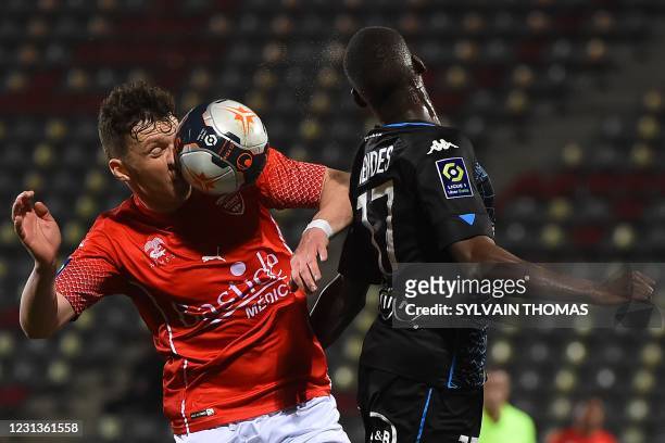 Nimes' Bosnian midfielder Haris Duljevic heads the ball with Lorient's French defender Houboulang Mendes during the French L1 football match between...