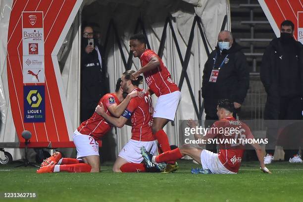 Nimes' French forward Renaud Ripart celebrates with teammates after scoring during the French L1 football match between Nimes Olympique and FC...