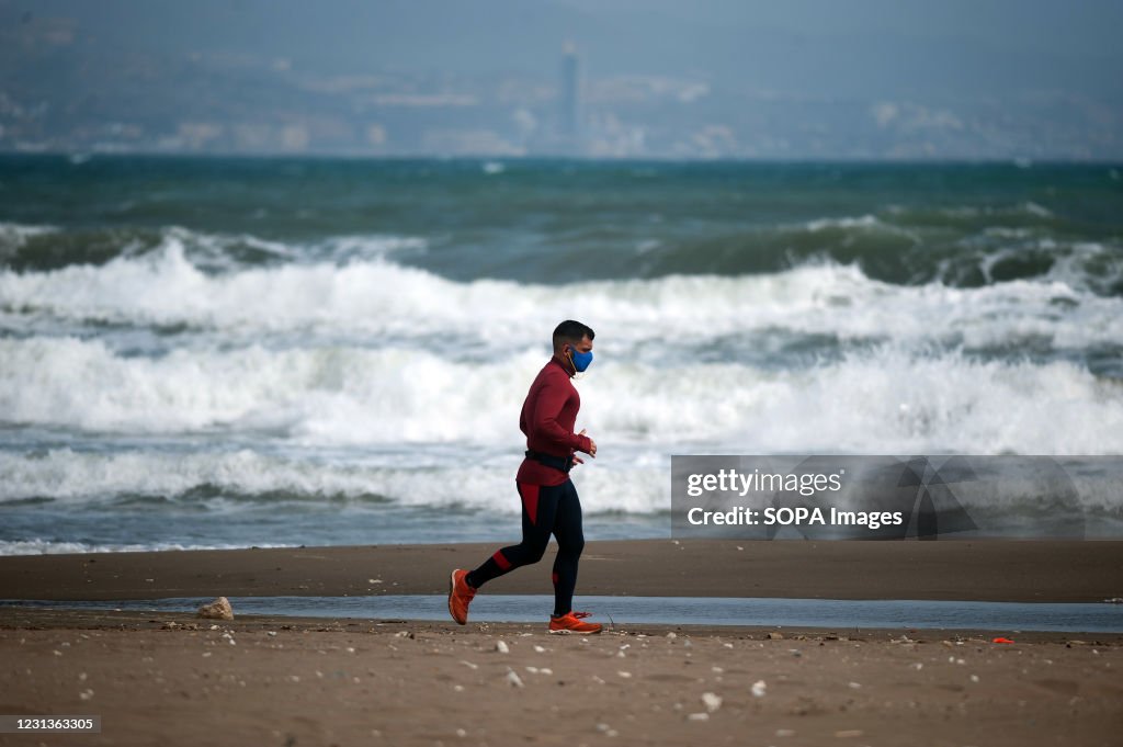A man wearing a face mask is seen jogging along Misericordia...