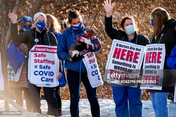 Registered Nurses and supporters stand in a picket line and wave to cars as they drive by outside St. Vincent Hospital in Worcester, Massachusetts on...
