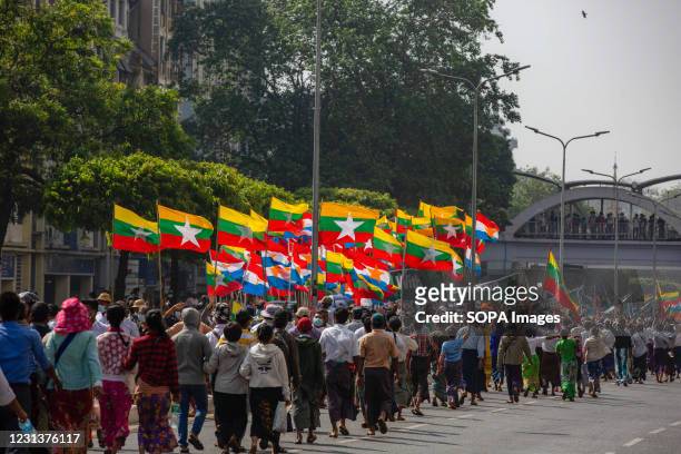 Pro-military protesters march around the city holding flags during the military coup protests. Myanmar's military detained State Counsellor of...