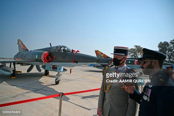 French military and a Pakistani air force officials look at Mirage fighter aircrafts during a 50th anniversary ceremony of the induction of...