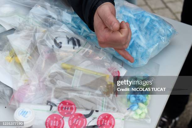 Policeman points cocaine bags seized to local dealers during a visit of French Interior Minister in Marseille, southern France, on February 25, 2021.