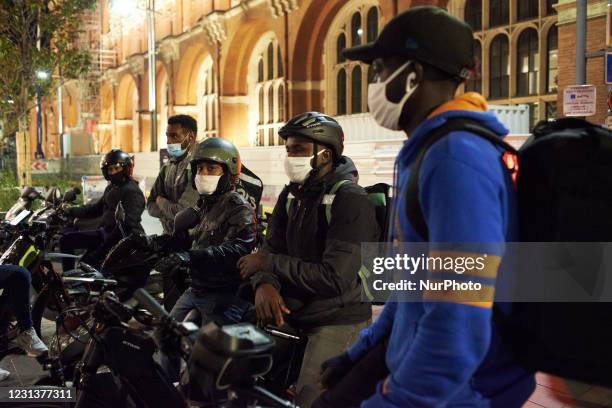 Delivery workers wait for their orders during the Covid-19 curfew. Food delivery industry has boomed in the past year as the pandemic forced people...