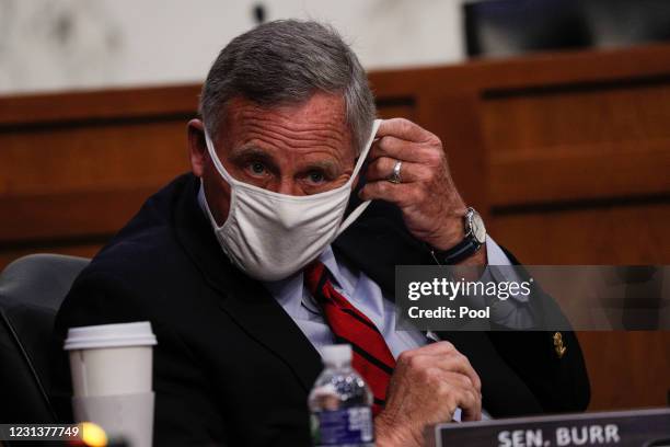 Ranking Member Sen. Richard Burr adjusts his mask at the confirmation hearing for Vivek Murthy and Rachel Levine before the Senate Health, Education,...