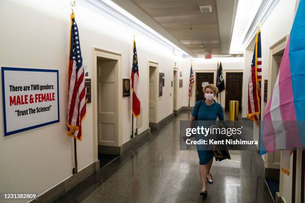 Woman walks through a hallway between the offices of Rep. Marie Newman and Rep. Marjorie Taylor Greene where Greene put a transphobic sign up, on...