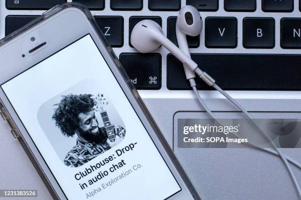 In this photo illustration, a Clubhouse app seen displayed on a smartphone with headphones on a laptop keyboard.