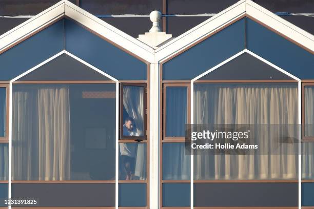 Hotel guest looks out of a window at the Radisson Blu hotel, Heathrow Airport, where travellers are completing their quarantine period on February...