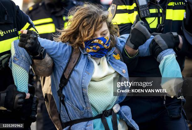 An activist is removed by police as during a demonstration by Extinction Rebellion outside the Overtoom in Amsterdam-West, as police move some of the...