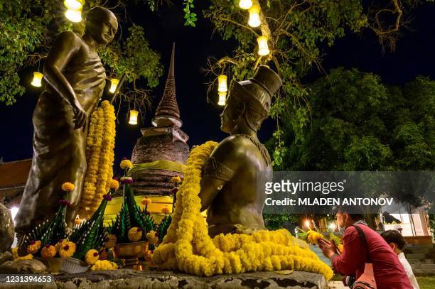 Devotees pray at Wat Traphang Thong to celebrate Makha Bucha Day in Sukhotai on February 26, 2021.