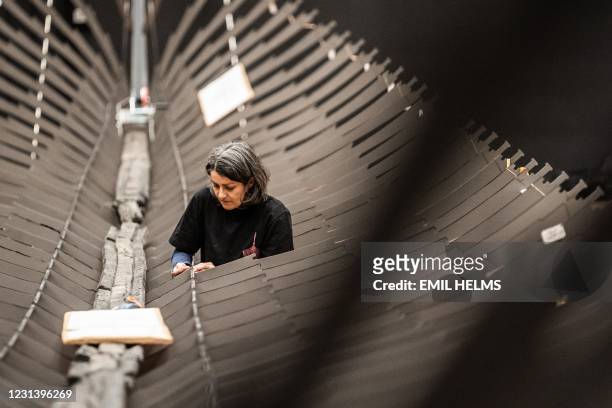 Museum worker assembles the Viking ship 'Roskilde 6' at the National Museum in Copenhagen on February 26, 2021. - The ship wreck was found in...