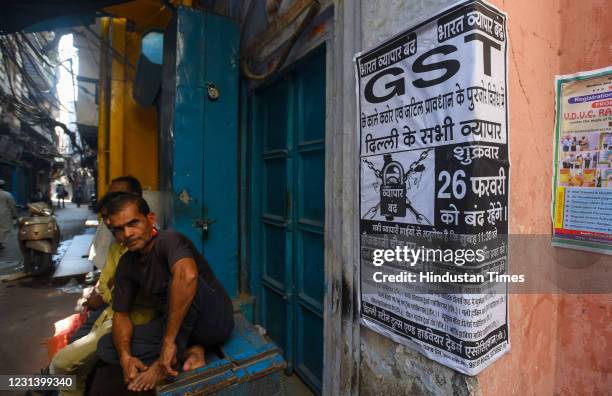 Workers sitting outside closed shops during a nationwide 'Bharat Bandh' strike called by several trade unions against fuel price hikes and GST taxes,...
