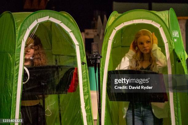 Emma Banker and Jessi McIrvin record vocals in pop-up tents during choir class at Wenatchee High School on February 26, 2021 in Wenatchee,...