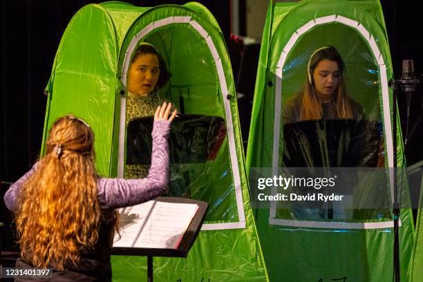 Choir director Dawn McCormick leads students Keyonna Page-Green and Faith Colman as they record vocals in pop-up tents during choir class at...