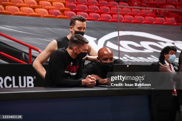 Duncan Robinson of the Miami Heat talks to Player Development Coach Anthony Carter of the Miami Heat and Assistant Coach/Director of Player...