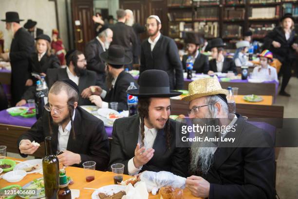 Ultra Orthodox jewish men, some wearing a costume celebrate the holiday of Purim in a synaguge on February 26, 2021 in Bene Beraq, Israel. The...