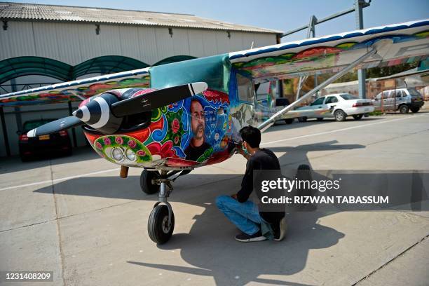 An artist gives finishing touches to a Cessna aircraft with a painted portrait of Indian Air Force pilot Abhinandan Varthaman, whose plane was shot...