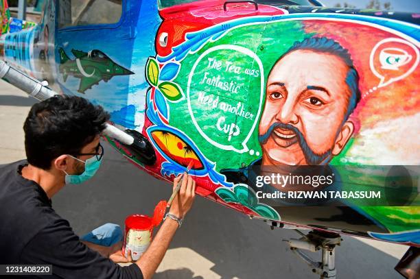 An artist gives finishing touches to a Cessna aircraft with a painted portrait of Indian Air Force pilot Abhinandan Varthaman, whose plane was shot...