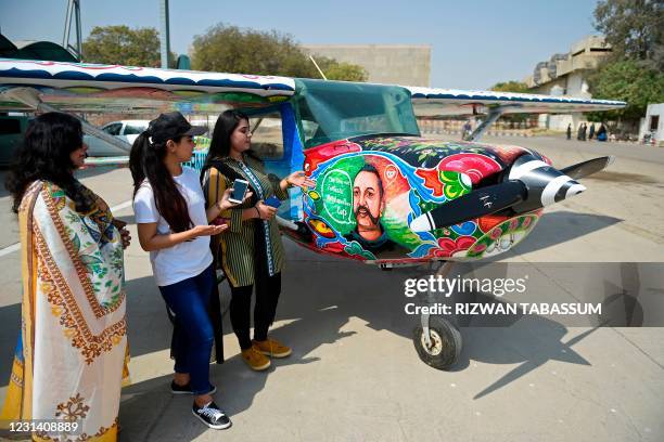 Visitors look at a Cessna aircraft with a painted portrait of Indian Air Force pilot Abhinandan Varthaman, whose plane was shot down and captured...