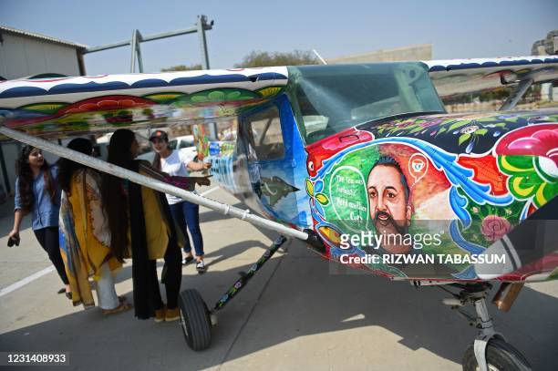 Visitors look at a Cessna aircraft with a painted portrait of Indian Air Force pilot Abhinandan Varthaman, whose plane was shot down and captured...