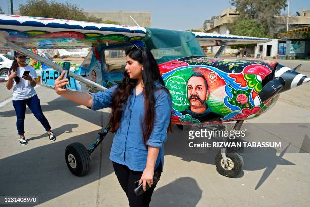 Visitor takes her selfie next to a Cessna aircraft with a painted portrait of Indian Air Force pilot Abhinandan Varthaman, whose plane was shot down...