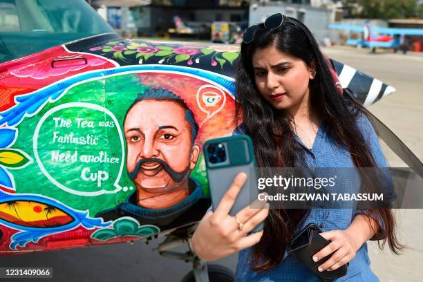 Visitor takes her selfie next to a Cessna aircraft with a painted portrait of Indian Air Force pilot Abhinandan Varthaman, whose plane was shot down...