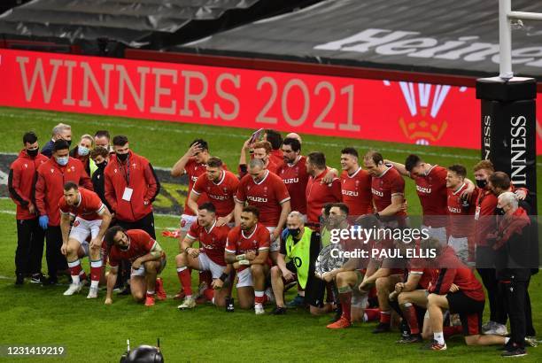 Wales' centre George North holds the triple crown trophy as Wales celebrate after the Six Nations international rugby union match between Wales and...