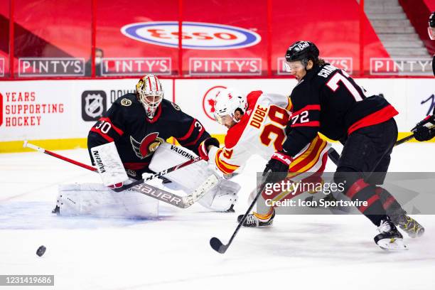 Ottawa Senators Goalie Matt Murray tracks a loose puck with Calgary Flames Winger Dillon Dube and Ottawa Senators Defenceman Thomas Chabot battling...