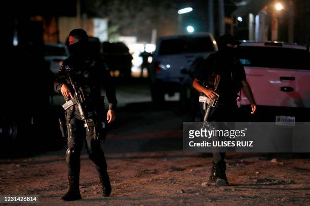 Police guard the place where 11 people were executed after an armed attack in the community of Tonala, state of Jalisco, Mexico, on February 27, 2021.