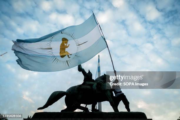 Protester hanging from the monument to Manuel Belgrano with a "Pro life" flag during the demonstration. Demonstrators gathered at Plaza de Mayo to...