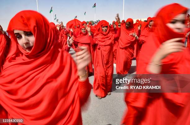 Sahrawi women perform a dance following a military parade during celebrations marking the 45th anniversary of the declaration of the Sahrawi Arab...