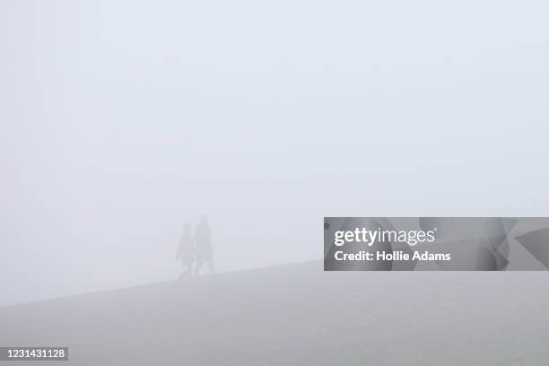 People walking in the fog at Parliament Hill on February 28, 2021 in London, England. February concluded with springlike temperatures around the UK...