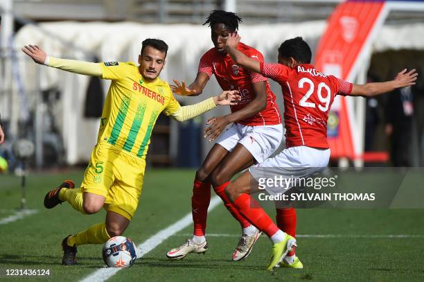 Nantes' Spanish midfielder Pedro Chirivella vies for the ball with Nimes' French defender Sofiane Alakouch and Nimes' French midfielder Lamine Fomba...