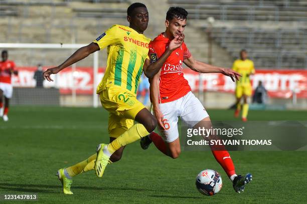 Nantes' French forward Randal Kolo Muani vies for the ball with Nimes' French defender Florian Miguel during the French L1 football match between...