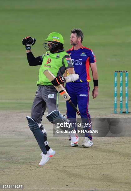 Lahore Qalandars' David Wiese celebrates after winning the match as Karachi Kings' Daniel Christian looks on at the end of the Pakistan Super League...