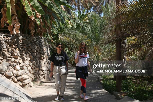 Omani women walk on a hiking trail in the village of Misfat al-Abriyeen situated on the escarpments of Oman's Grand Canyon, on February 8, 2021. -...