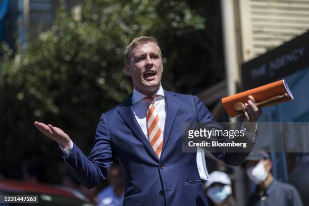 An auctioneer gestures while speaking to bidders during an auction of a residential property in the Paddington suburb of Sydney, Australia, on...