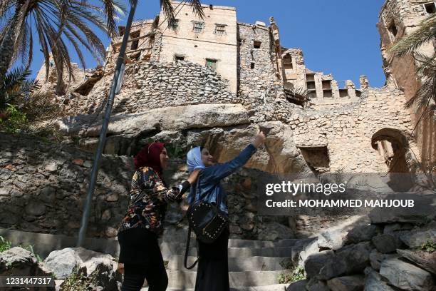 Egyptian tourists take a selfie as they tour the village of Misfat al-Abriyeen situated on the escarpments of Oman's Grand Canyon, on February 8,...