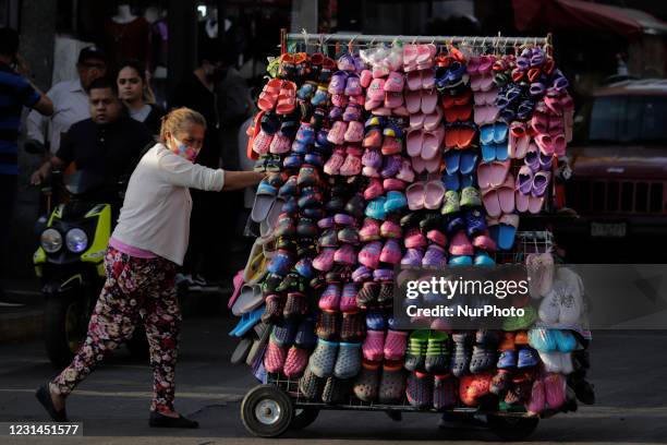 Woman selling plastic sandals in the streets of Iztapalapa during the COVID-19 emergency and the orange epidemiological traffic light in Mexico City....