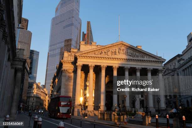 With modern offices of financial institutions behind, an architectural sunlit view of the friezes and Latin inscriptions on the pediment of the Royal...