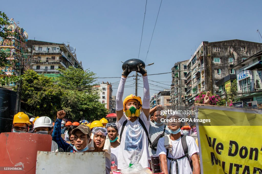 An anti military coup protester holds a monk bowl while...