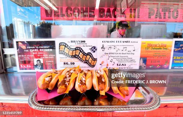 Restaurant workers wear faceshields and facemasks during the reopening of iconic LA restaurant Pink's Hot Dogs on March 1, 2021 in Los Angeles,...