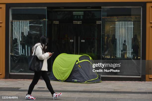 Young woman walks past a rough sleeper's tent on Grafton Street in Dublin city center during Level Five Covid-19 lockdown. On Monday, March 1 in...