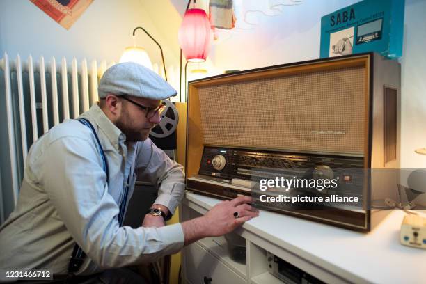 February 2021, North Rhine-Westphalia, Datteln: Kevin Nikodem operates a 1950s radio in his home. Nikodem lives like he did in the 50s. He has...