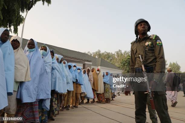 Soldiers stands next to a group of girls previously kidnapped from their boarding school in northern Nigeria are seen on March 2, 2021 at the...