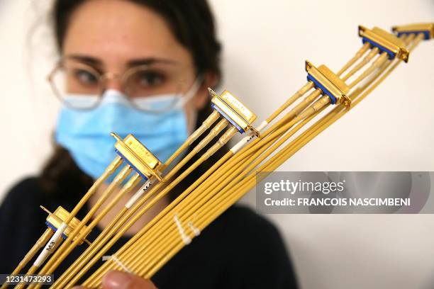 An employee of Axon'Cable, specialist in custom-designed interconnect, shows cables made for the aeronautics and aerospatial sectors at the company's...