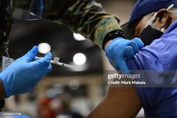 Member of the U.S. Armed Forces administers a dose of the Pfizer COVID-19 vaccine at a FEMA community vaccination center on March 2, 2021 in...