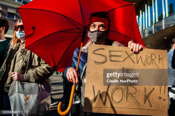 Woman is holding a placard saying Sex work is work, before the Peepshow started as a part of the sex workers demonstration demanding back to work, in...